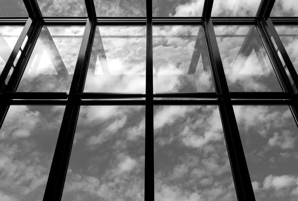 Verrière en acier et ciel nuageux, vue de dessous